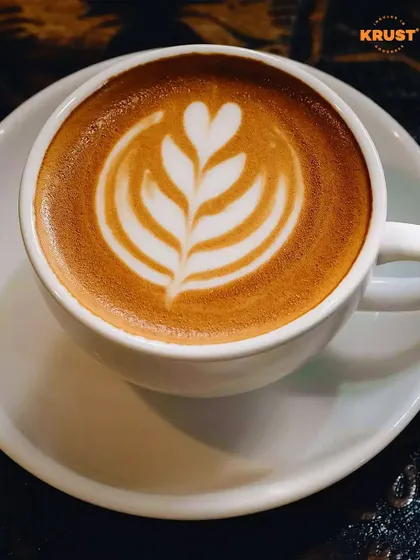 A simple, elegant cup of coffee with leaf-patterned latte art. This is the kind of beautiful result you can learn to create consistently.