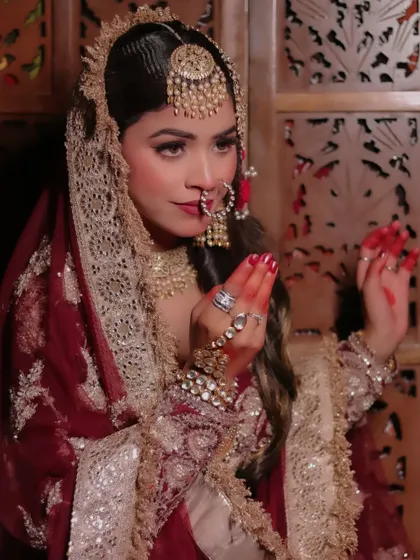 A candid shot of the bride with alta-adorned hands. This photo captures a traditional element of bridal beautification, adding cultural depth to the portrait.