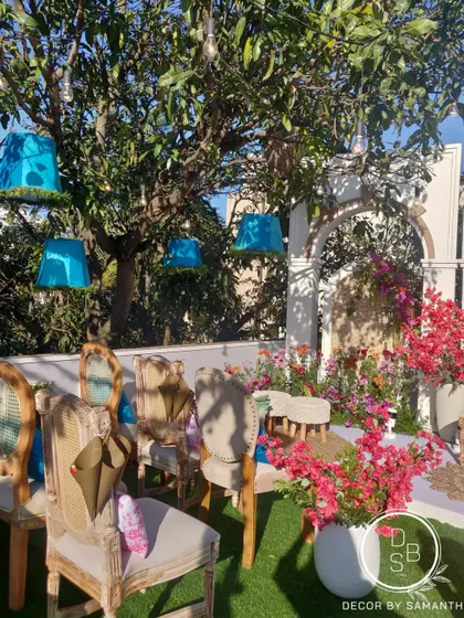 Every element reimagined. We hung bright blue lampshades from the trees and used a mix of vintage-style chairs to create an eclectic and playful seating area for guests.