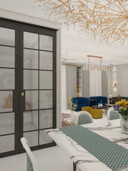 A serene view from the dining area into the living room of Villa 72. The design features a beautiful mandir with glass doors, a statement chandelier, and a cohesive color palette that connects the different zones of this spacious home.