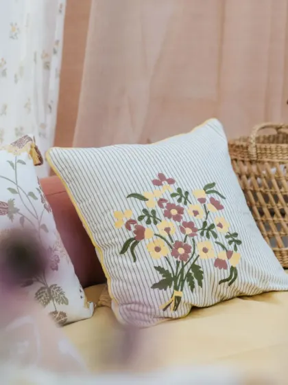 An intricately embroidered cushion cover from our 'Pause' collection. The bouquet of flowers in muted tones adds a layer of charm and artistry to your sofa or bed.
