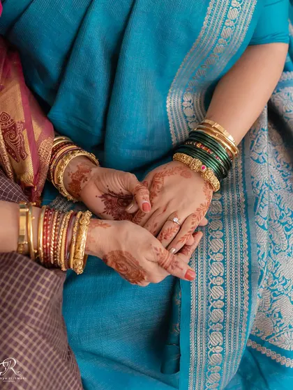 A close-up of two women holding hands, a simple yet powerful image of connection and support at a home wedding.