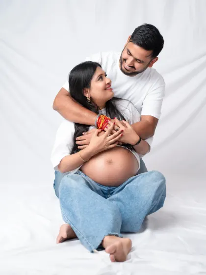 A warm and joyful embrace from behind. This casual portrait captures the fun, loving dynamic of the expecting couple.