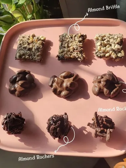 Can you pick a favourite? This platter showcases three of my signature chocolate nut clusters: Almond Brittle, Almond Rocks, and Almond Rochers. Each offers a unique crunchy and chocolatey experience.