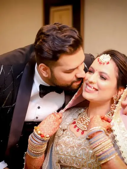 A sweet moment between siblings on the wedding day. The brother gives his sister a loving kiss on the cheek, a beautiful, candid expression of family love.