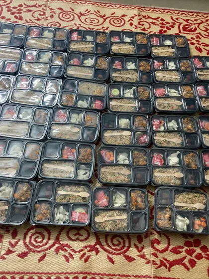 Packed vegetable fried rice boxes are arranged for our 35-kid birthday order, with Gobi Manchurian, gulab jamun and fryum.