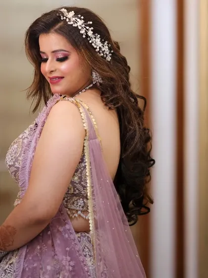 A close-up profile shot, highlighting the intricate hair accessory and the soft, shimmery eye makeup.