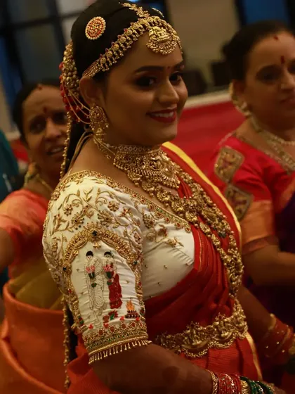 The bride looks absolutely radiant. The custom embroidery on her sleeve, depicting a wedding ceremony, is a beautiful detail that celebrates her special day.