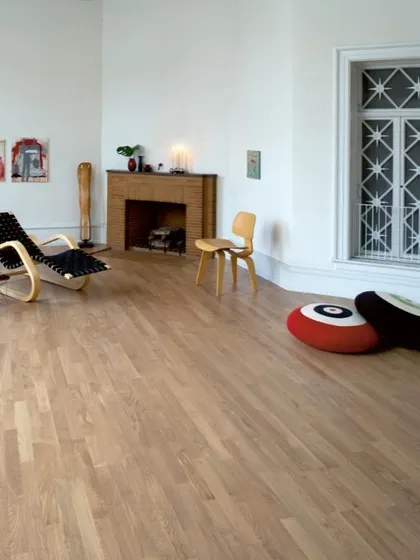 This minimalist room is enhanced by a simple, light-colored hardwood floor. It serves as a clean, warm foundation that supports a modern and uncluttered aesthetic.