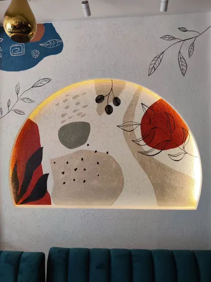 A close-up of one of the backlit abstract murals at Cafe Berni. The lighting enhances the colors and textures of the artwork.