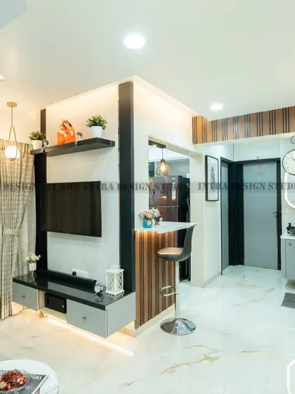 This shot highlights the seamless flow from the living area to the dining space and open kitchen. The custom TV unit and breakfast bar are designed with matching vertical wooden slats, creating a cohesive and stylish look.