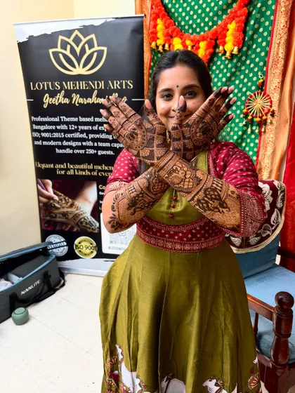The beautiful bride Chandana posing with her completed Radha-Krishna themed mehendi, a true work of art.
