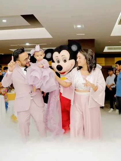 A family poses with the Mickey Mouse mascot amidst a cloud of dry ice, making for a dramatic and fun photo.