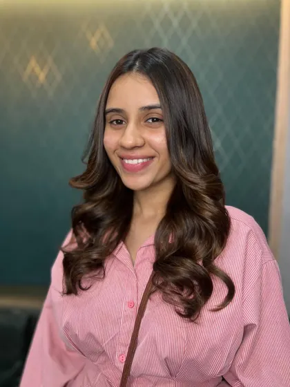 A happy client showing off her new luscious brown curls. The color is rich and the style is fun and vibrant.