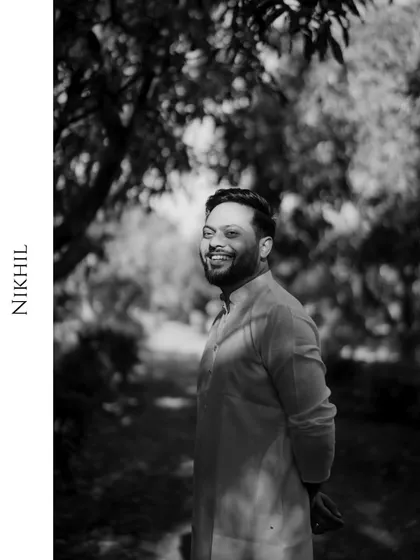 A classic black and white portrait of the groom, smiling happily before his Haldi ceremony.
