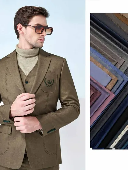 Step into a blend of rich heritage and modern flair. This image showcases a brown three-piece suit with an embroidered crest, alongside a selection of our finest fabrics.