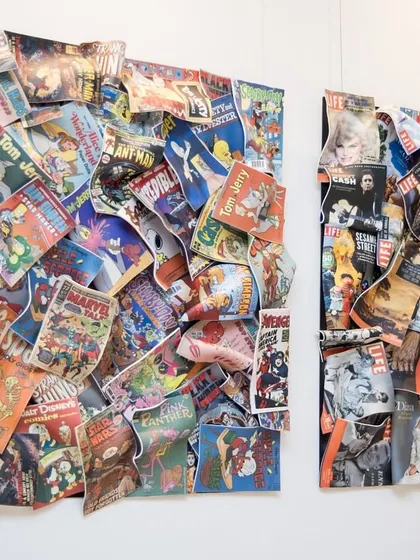 A side view of the "Comic Confluence" and "Chronicles of Life" installations, showing their 3D, layered construction.