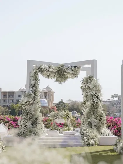 The floral mandap arch framing the iconic view of the Udaipur city palace across the lake. This destination wedding design was all about celebrating the beauty of the location.