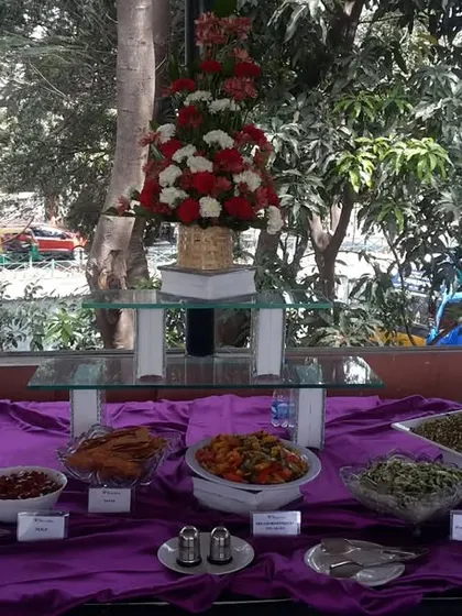 A closer view of our salad and appetizer section from a celebratory event. We use floral arrangements to enhance the beauty of our food displays.
