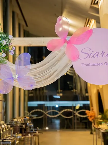 The entrance to "Siara's Enchanted Garden," featuring a custom sign with sheer draping and butterfly accents.