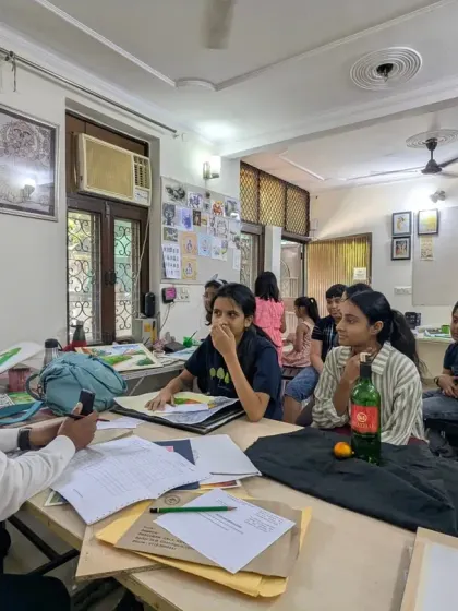 An interactive session in progress. Here, a guest artist is reviewing student work and providing valuable feedback, creating a dynamic learning environment.