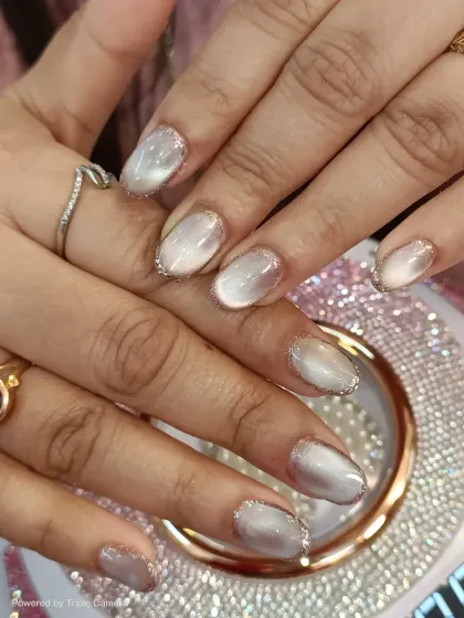 Another angle of the white cat-eye nails with glitter outlines. This view shows how the light plays on the magnetic polish, creating a beautiful, shifting dimension.