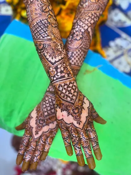 A crossed-hands pose showing the beautiful symmetry and intricate details of the bridal henna.