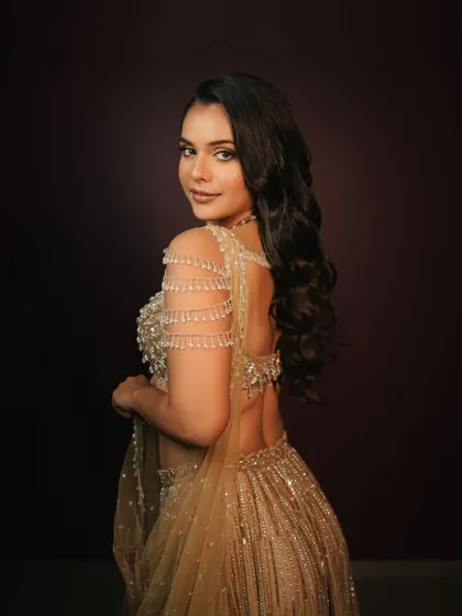 A beautiful back profile showing the flow of the hair and the intricate details of the outfit. The makeup is kept soft to balance the overall look.