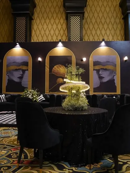 A wide shot of the lounge area, showing how the modern art, plush seating, and unique centerpieces come together against the venue's classic architecture.