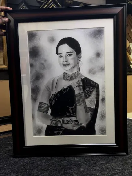 Beyond caricatures, I also create detailed realistic portraits. This framed piece shows the depth and emotion I can capture using charcoal and graphite for a timeless work of art.