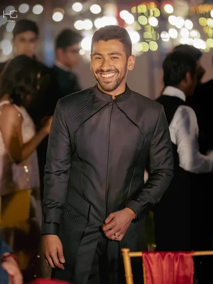 A candid shot showing the achkan in motion. It’s designed to be comfortable while maintaining its powerful, tailored shape throughout the celebration.