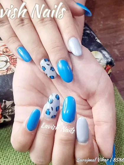 A fun and trendy set combining bright blue, grey, and a playful blue leopard print accent nail.