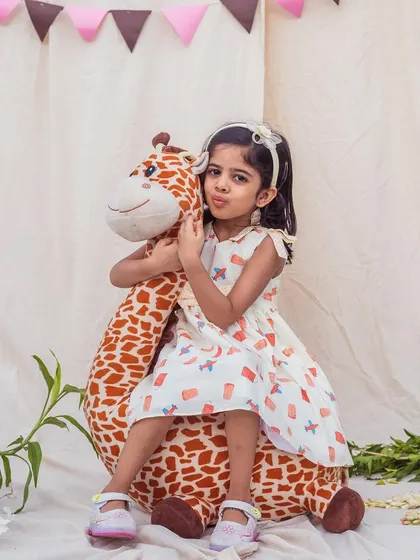 A sweet pose with a cuddly friend. This dress features a fun print of airplanes and gift boxes, perfect for a little adventurer.
