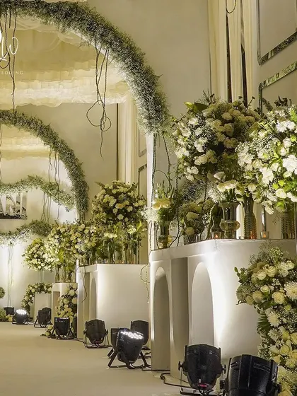 The enchanted forest theme continued with grand archways and massive arrangements of white flowers and baby's breath, creating a sense of scale and wonder.