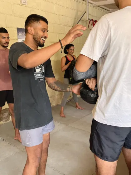 A coach demonstrating a technique with a kettlebell.