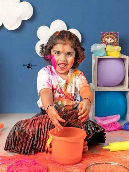The pure joy of getting messy. This toddler's colorful hands and face show just how much fun a Holi photoshoot can be.