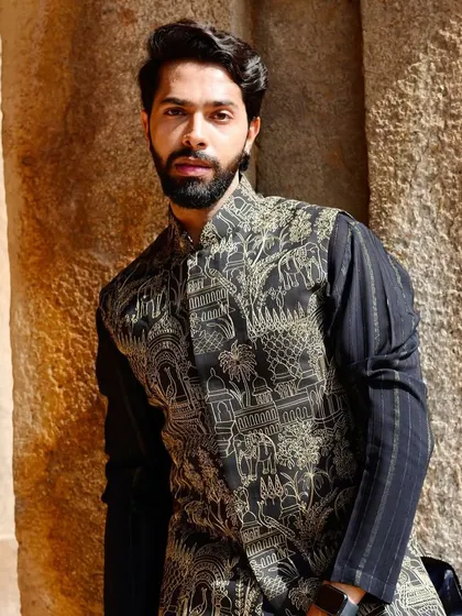A modern interpretation of traditional thread work. This black Nehru jacket features a detailed print of heritage architecture and elephants, worn over a textured black kurta for a sophisticated, layered look.