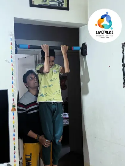 I'm providing support to a young client as he works on his pull-up strength. This encouragement helps build confidence and ensures safety.