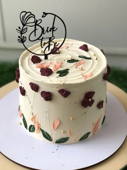 A lovely "Bride to be" cake with a rustic, wildflower-inspired buttercream design.