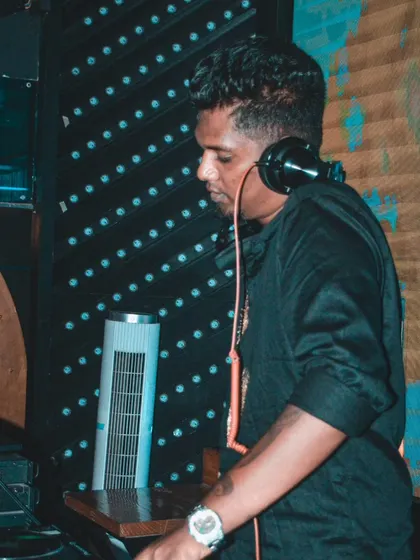 A profile shot of me mixing in a dimly lit club. My focus is always on the music and the technical side of creating a great set.