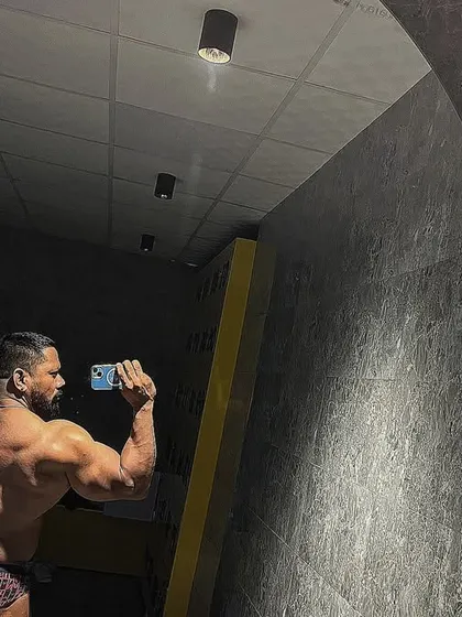 A back double bicep pose in the mirror. I am determined to win.
