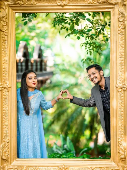 A fun and creative shot of a couple making a heart shape with their hands inside a golden frame.