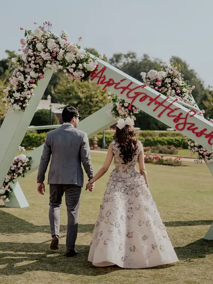 The couple makes their entrance at the welcome lunch, walking hand-in-hand through a custom-designed archway bearing their wedding hashtag.