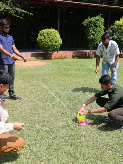 This activity requires delicate coordination and clear communication to move the object without dropping it. It is a perfect example of how our games mirror the collaborative challenges of the workplace.