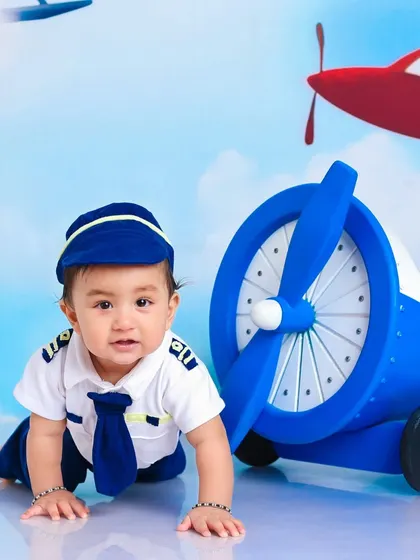 This little pilot is crawling towards his next adventure. It's a great shot that captures both the theme and the natural movement of a baby.
