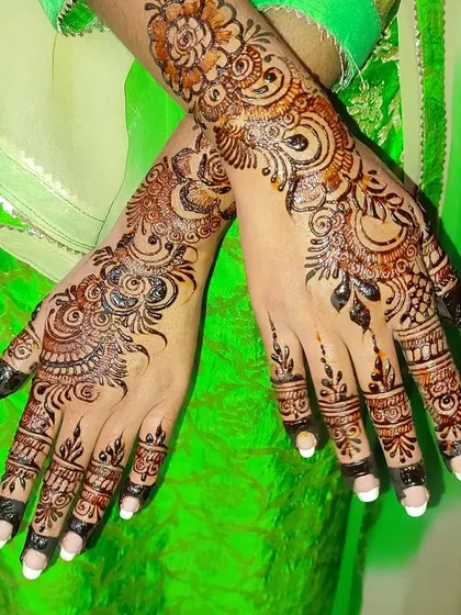 This design combines the boldness of Arabic henna with the delicate details of Indian patterns. The finger work is especially intricate, contrasting with the open space on the palm.