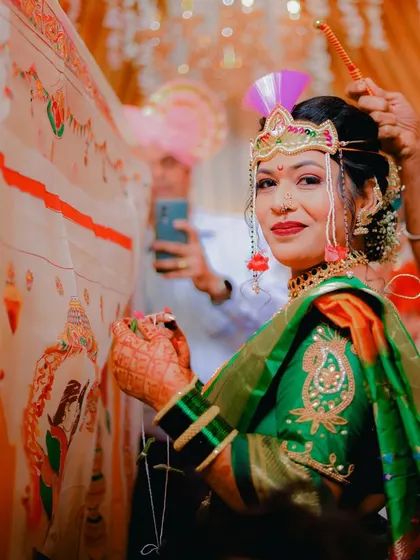 A beautiful shot of the Maharashtrian bride during the antarpat ceremony. She holds the thread, her eyes filled with emotion as she peeks from behind the ceremonial cloth.