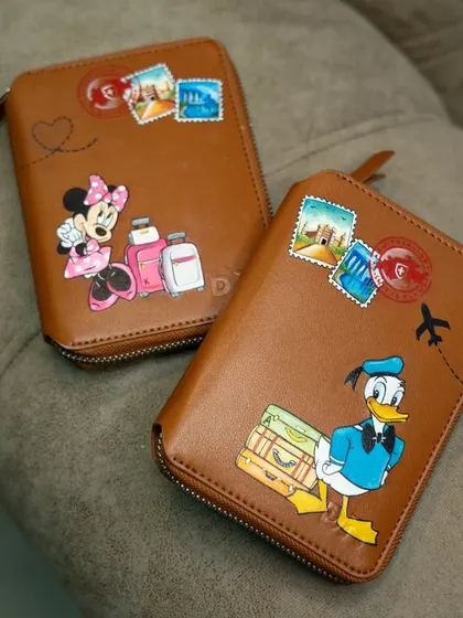 Getting ready for an adventure with these custom hand-painted passport covers, featuring Minnie and Donald Duck with their luggage.