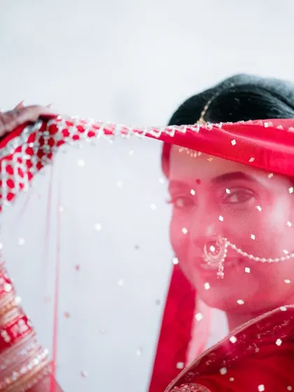 A shy bride peeks through her veil. This is a classic, delicate shot that we love to capture before the main ceremony.