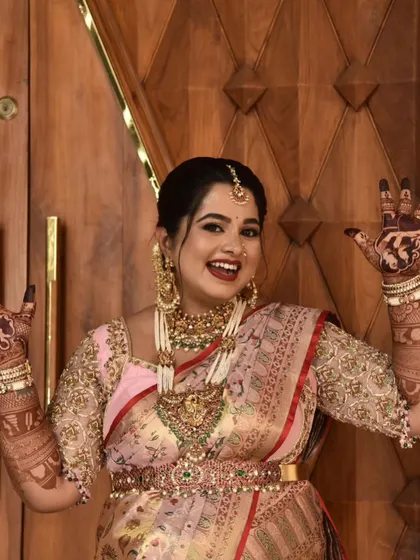 Pure happiness! A joyful mom-to-be shows off her beautiful baby shower mehendi. The design features couple portraits and other personal elements, making her smile even brighter.